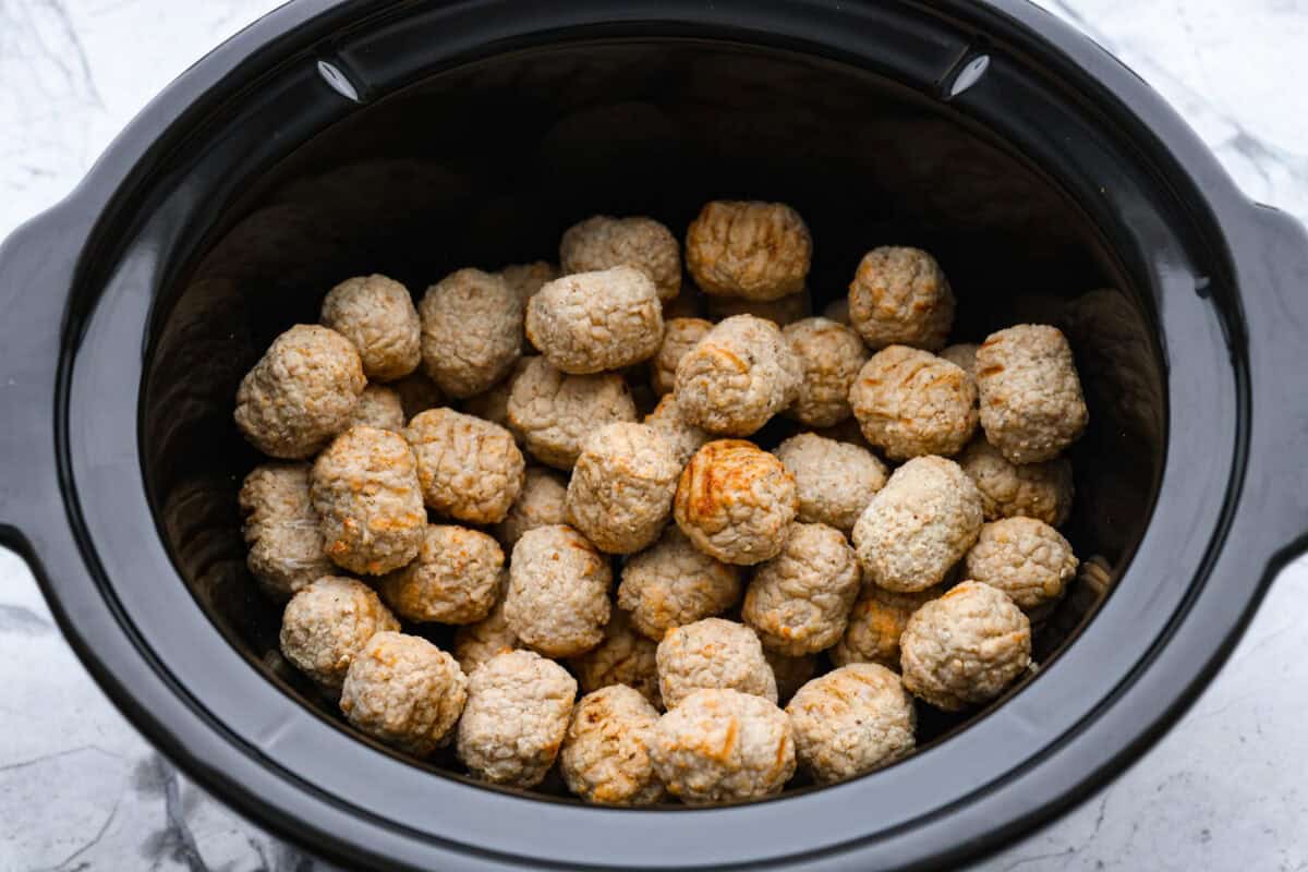 Frozen meatballs added to the bottom of the crockpot.