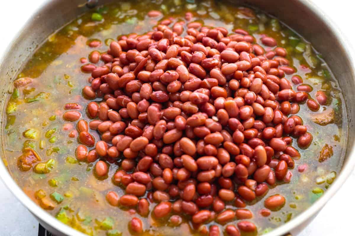 Beans and broth added to the skillet.