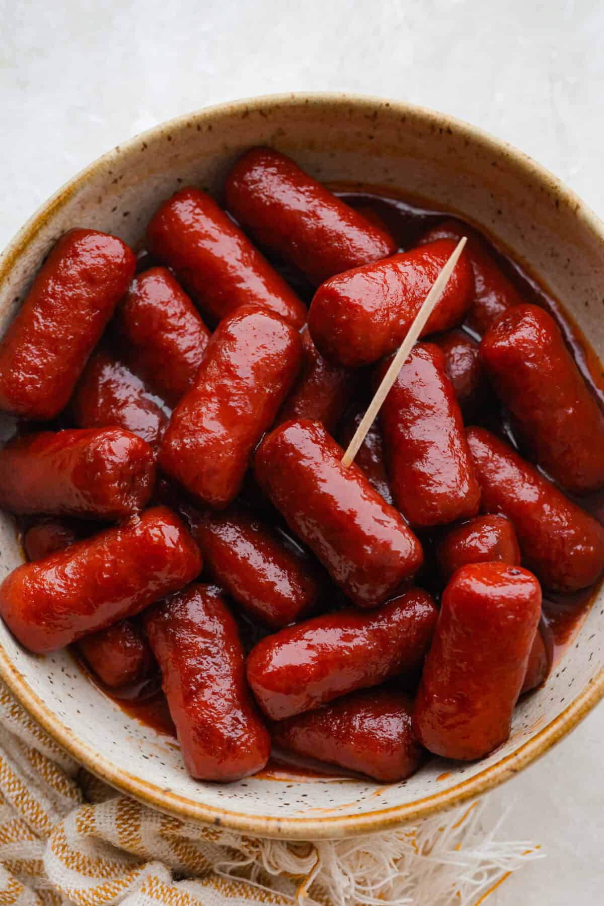 Cowl of crockpot grape jelly little smokies with a toothpick, ready to serve.