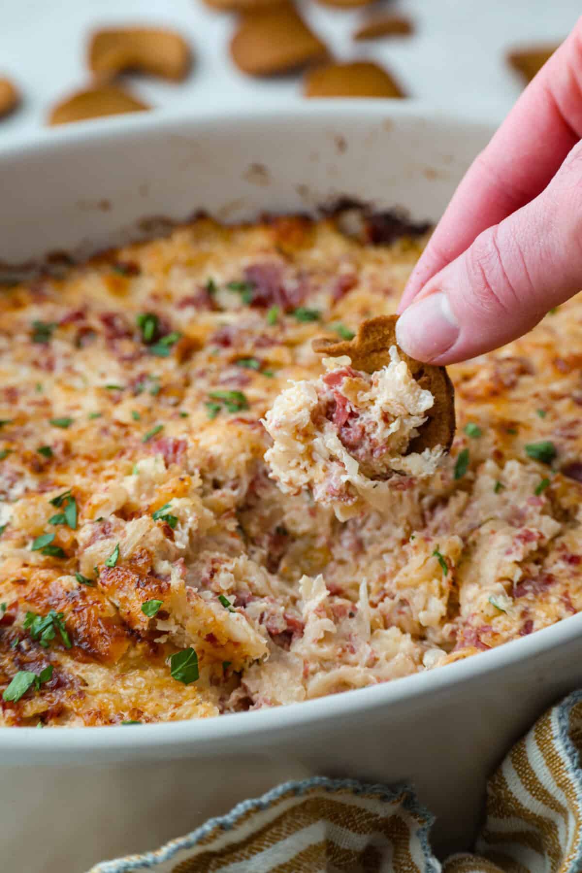 Someone scooping a bite of hot Reuben dip.