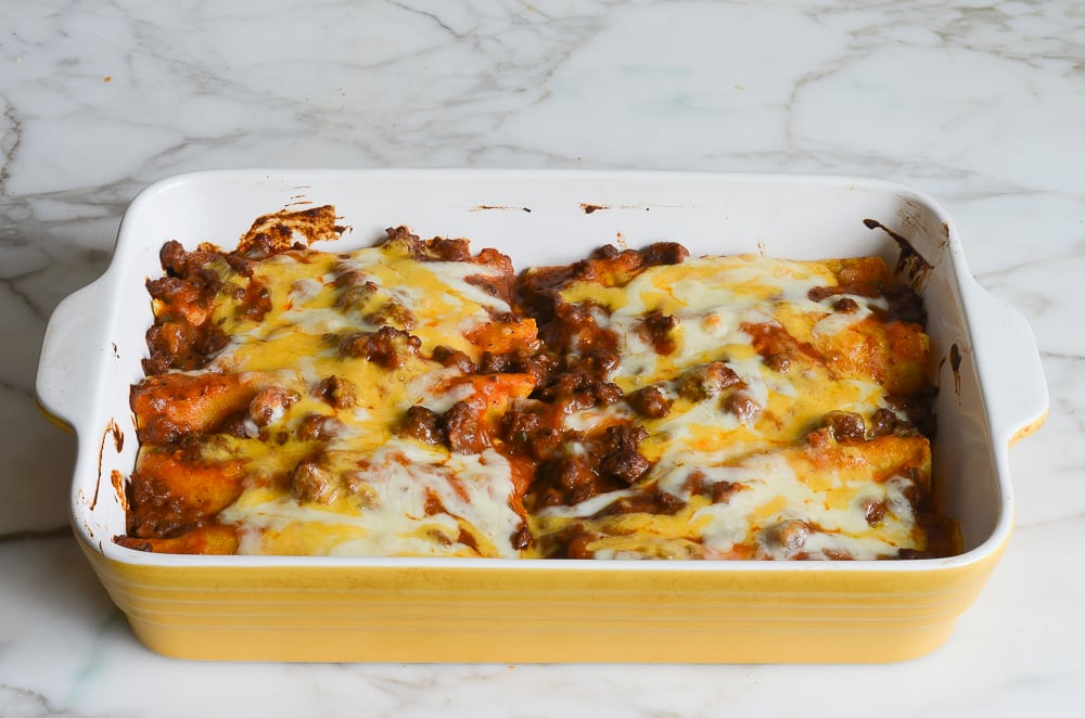 Baking dish of bubbling beef enchiladas.