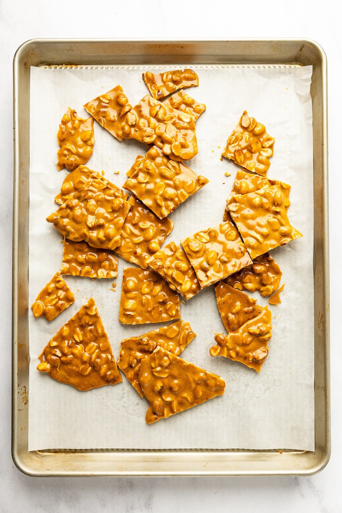 pieces of peanut brittle on parchment-lined baking sheet