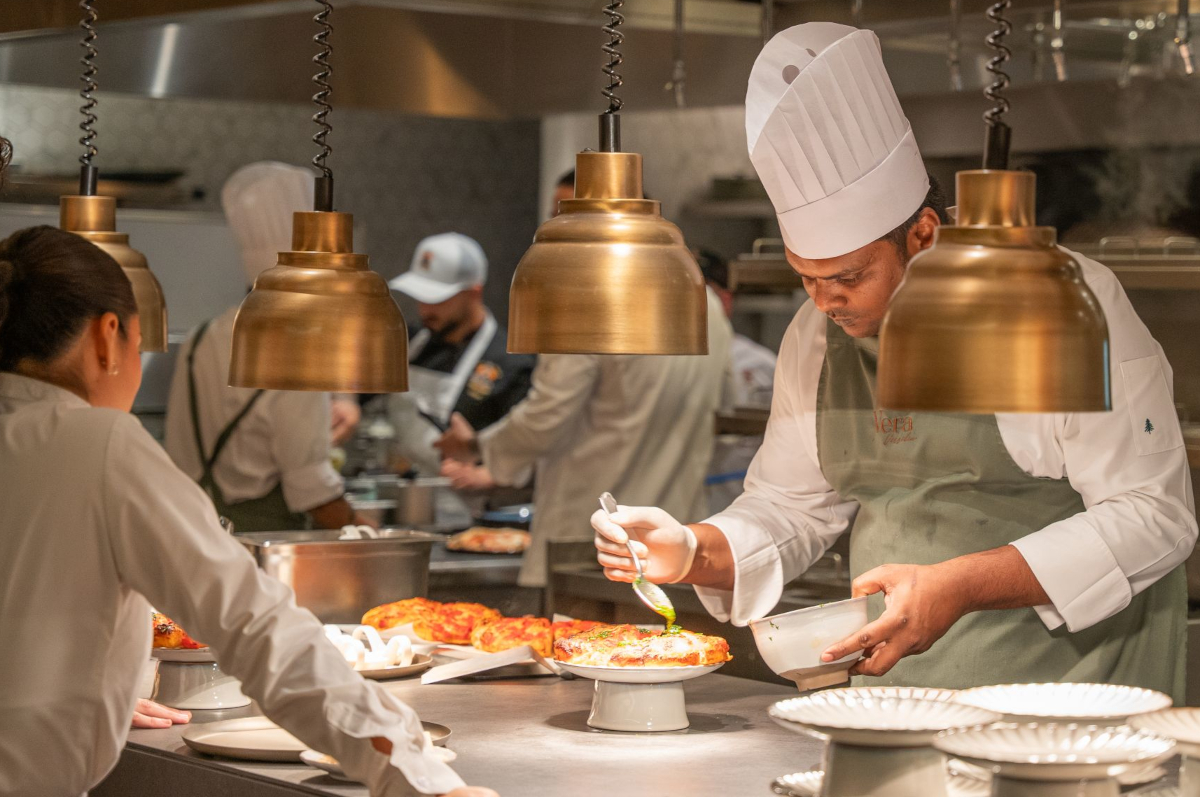 Italian culinary heritage - Chef preparing pizza in a restaurant kitchen. Culinary arts, food preparation.