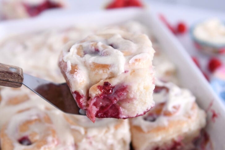 Baked raspberry sweet roll on metal spatula.