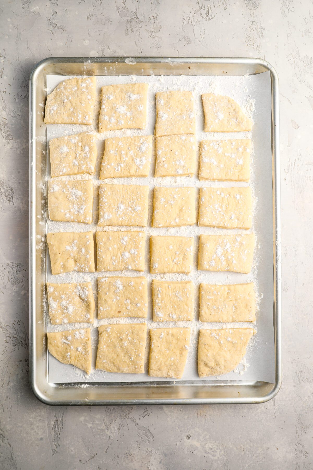 beignet dough squares on baking sheet