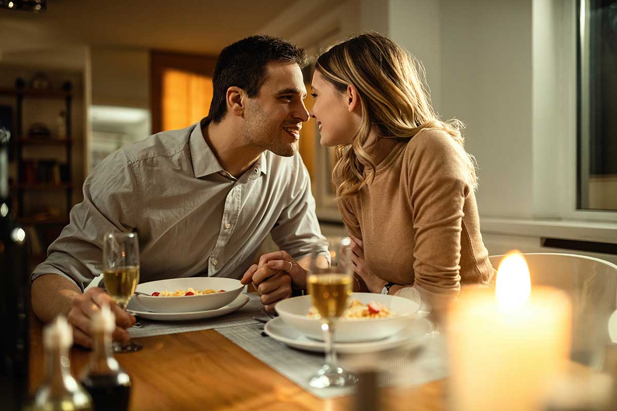 romantic pasta dinner for two with gourmet marinara sauce, candles, and wine on table set for date night
