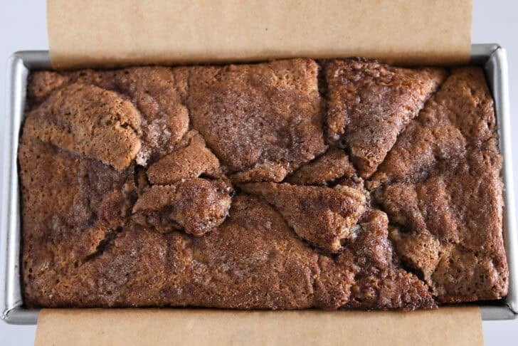 Loaf pan with baked cinnamon swirl bread.