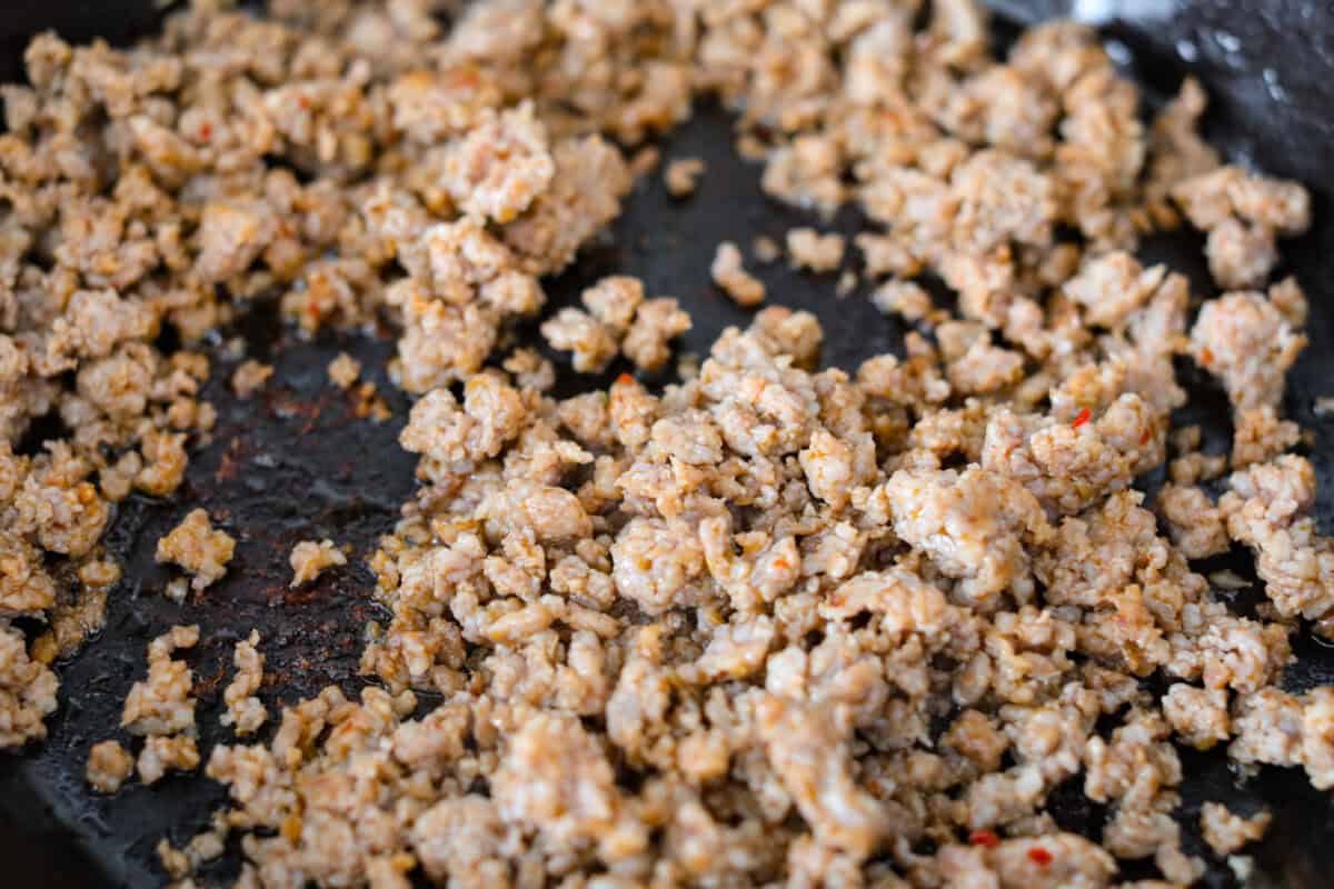 Sausage browning in the skillet. 