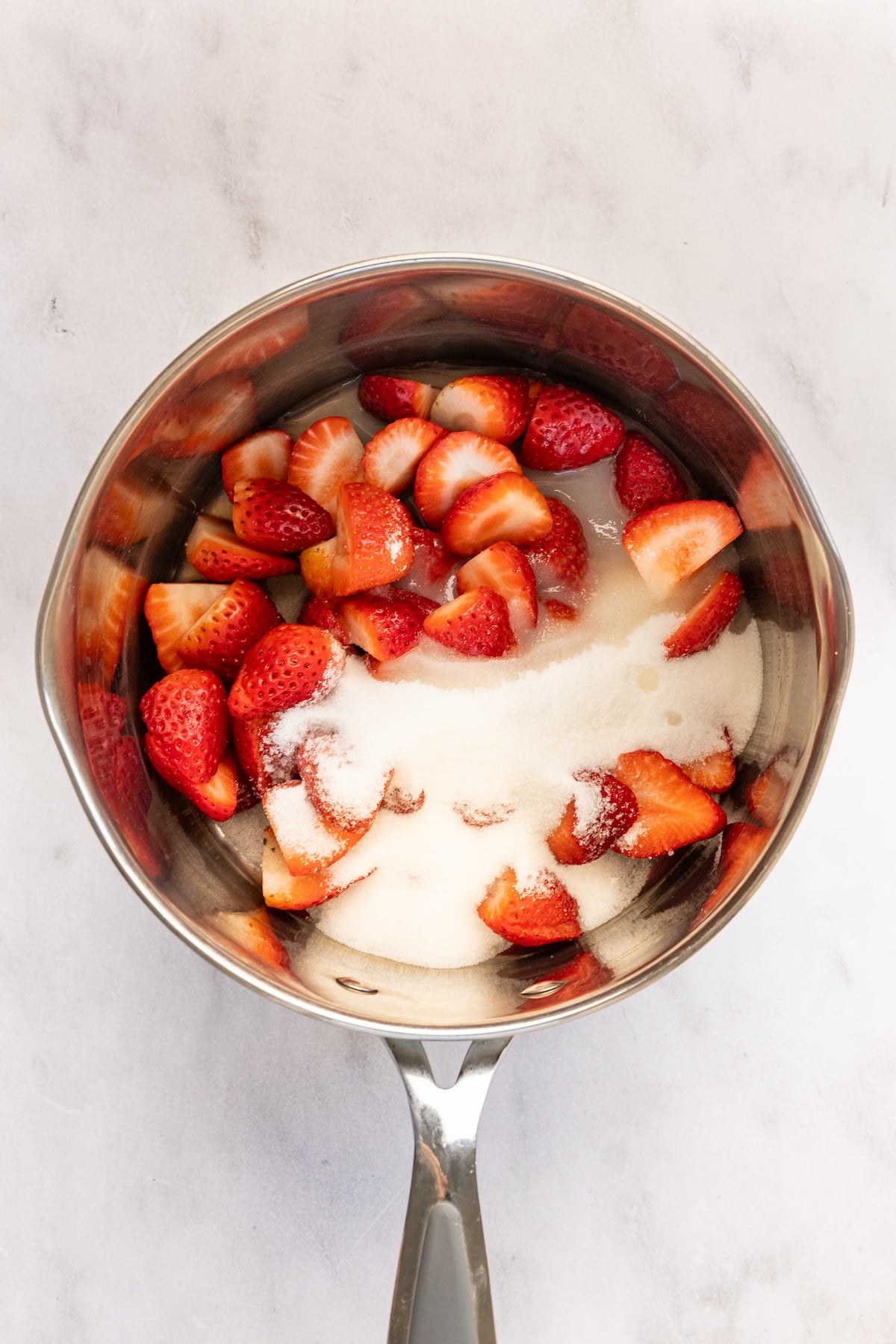 medium pot with strawberries, sugar, and lemon juice