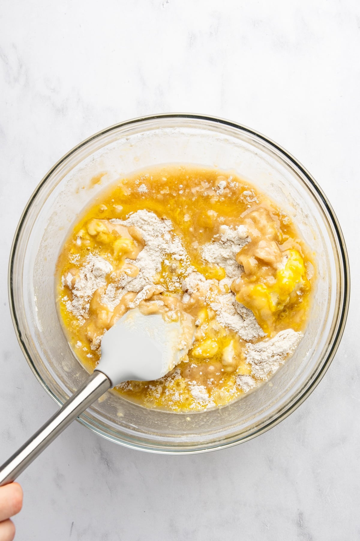 large bowl with wet ingredients added to flour, sugar, salt, baking soda, and cinnamon