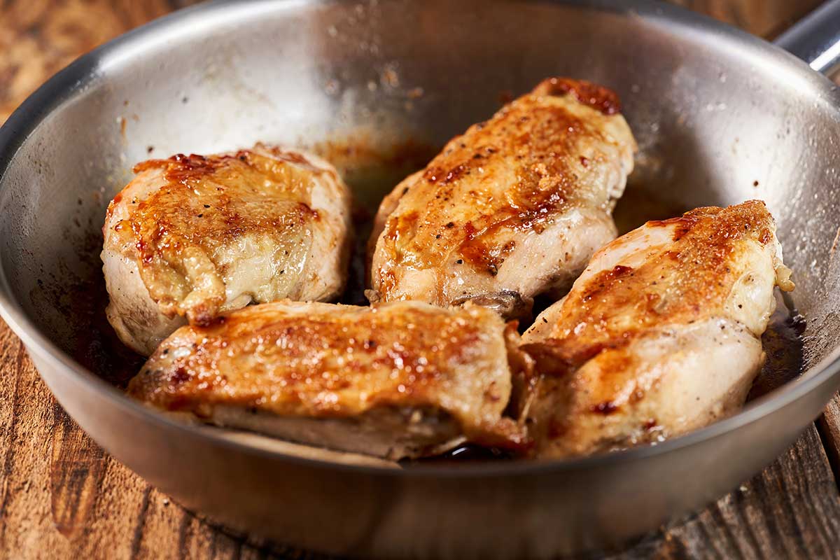 Chicken breast pieces searing golden brown in cast iron skillet for Marry Me Chicken Pasta
