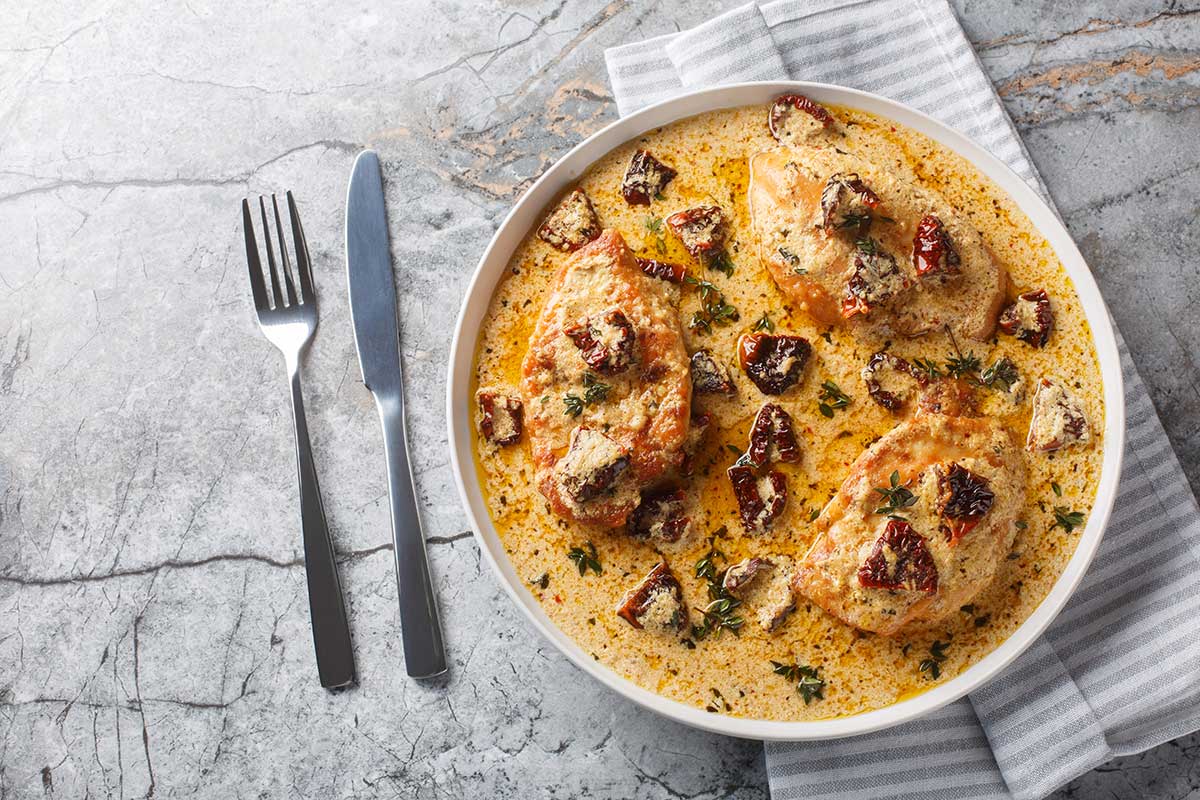 Classic Marry Me Chicken Pasta plated with fresh basil and grated parmesan — creamy sun-dried tomato sauce