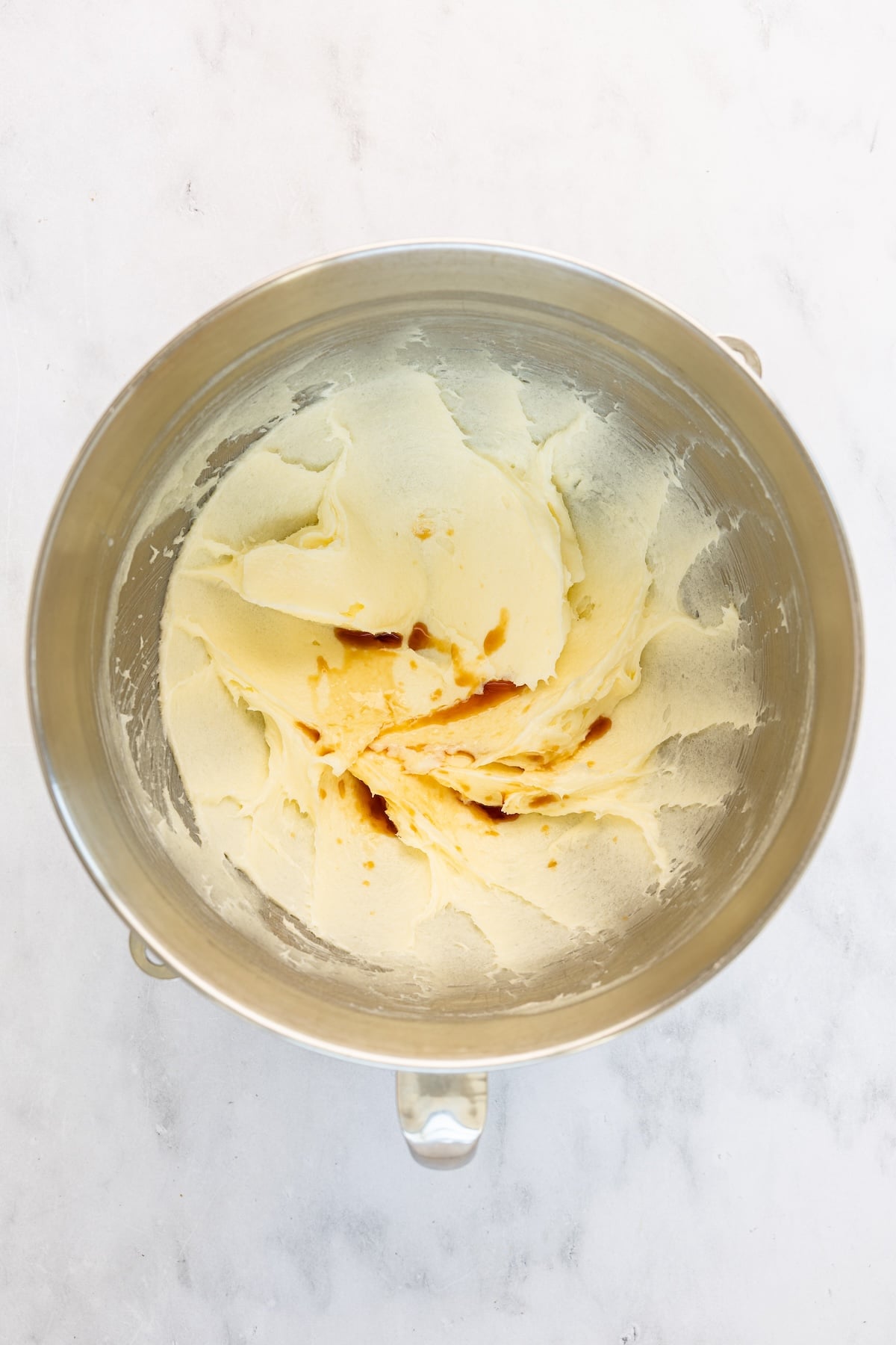 mixing bowl with vanilla added to butter, cream cheese, and sugar mixture