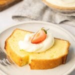 slice of cream cheese pound cake topped with whipped cream and strawberries