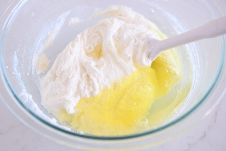 Glass bowl with egg whites added to cake batter.