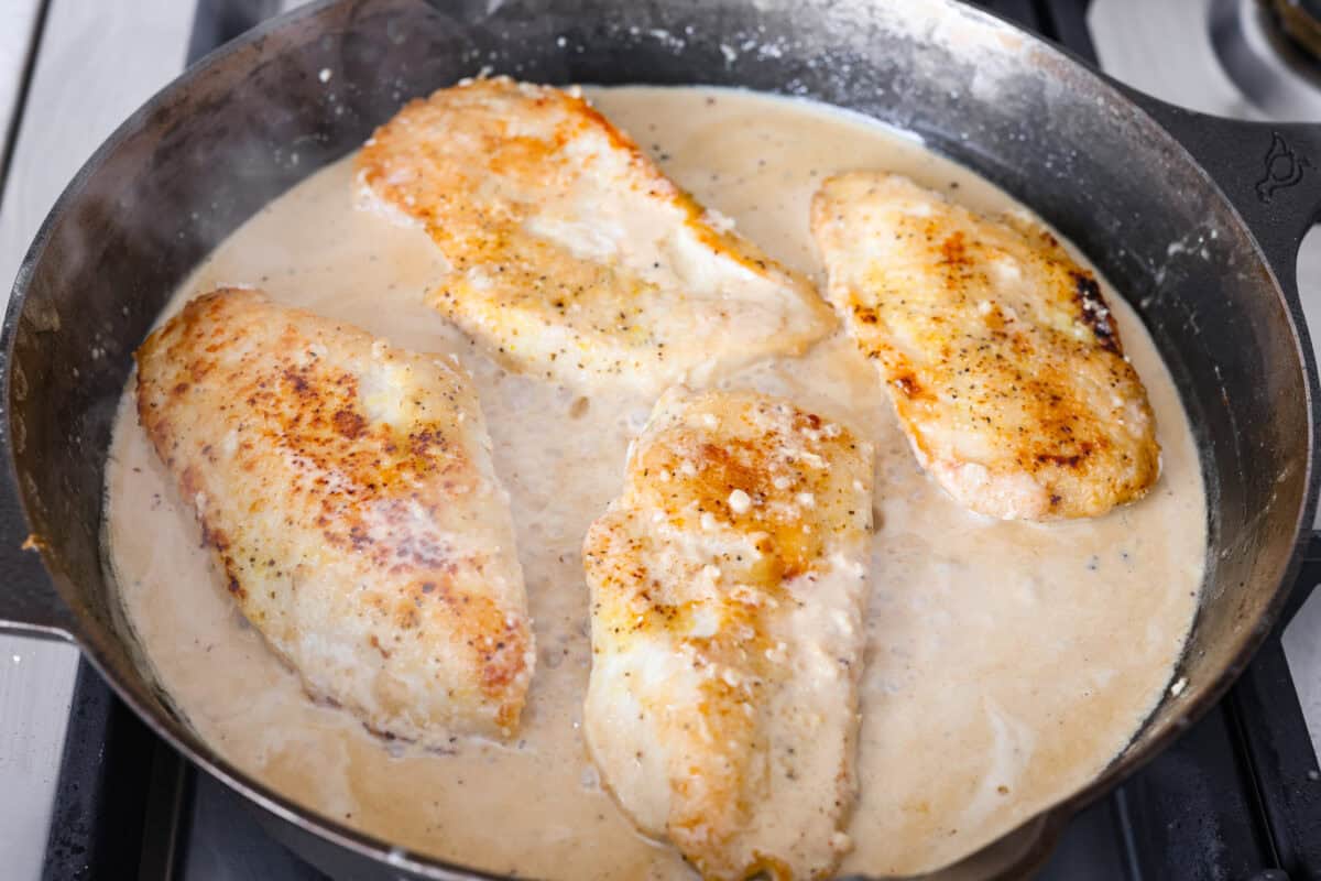 Chicken breasts added to the sauce in the skillet.