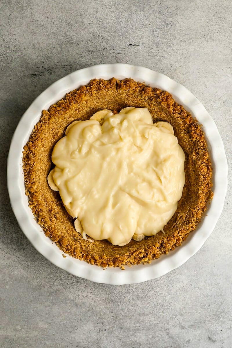pie crust with layer of custard over layer of sliced bananas