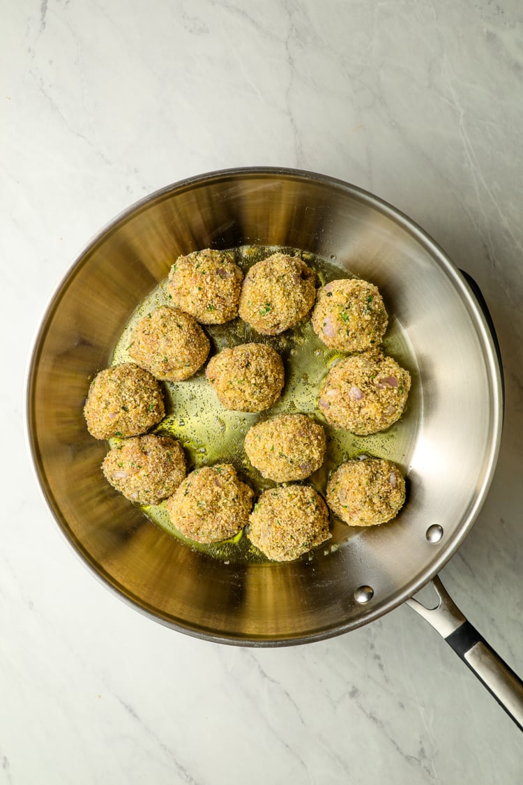 large skillet with chicken piccata meatballs added to oil