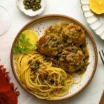 Chicken piccata meatballs with pasta and a glass of red wine.