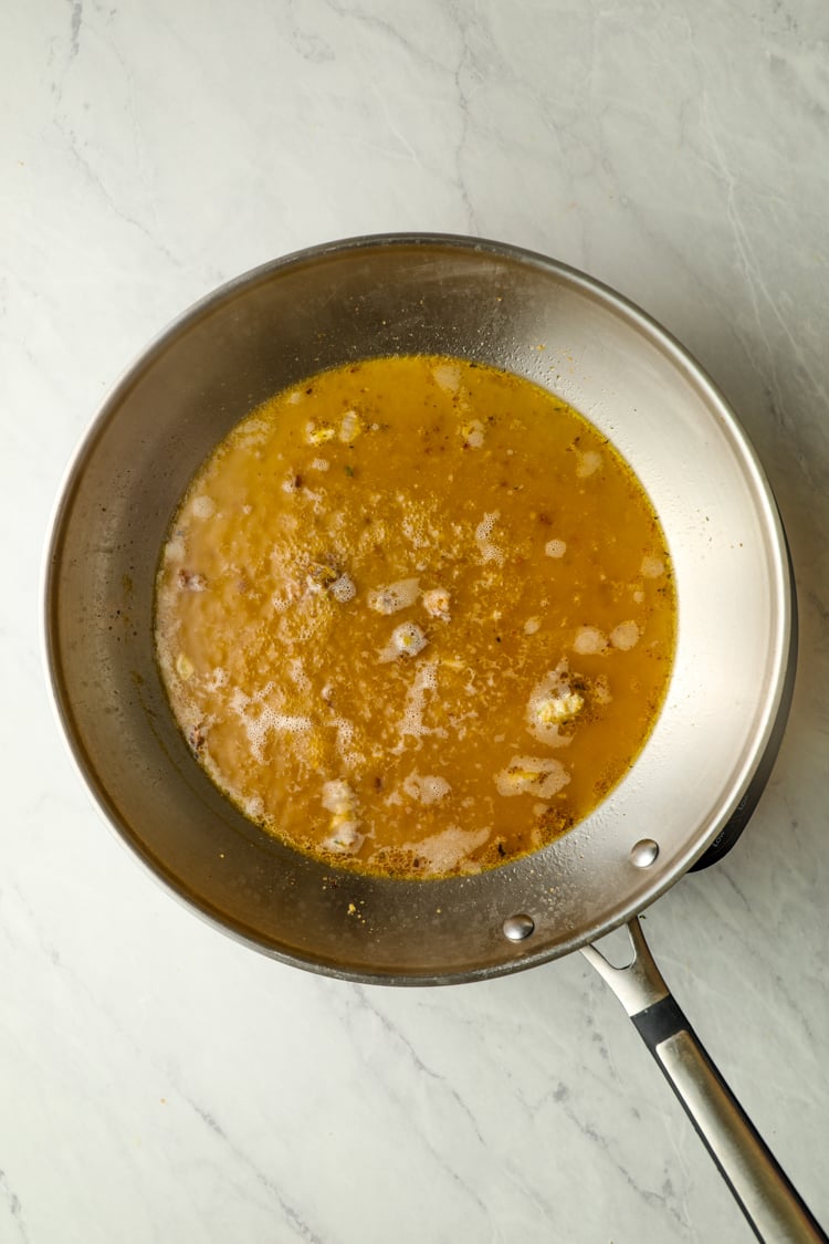 Reducing broth for chicken piccata meatballs.