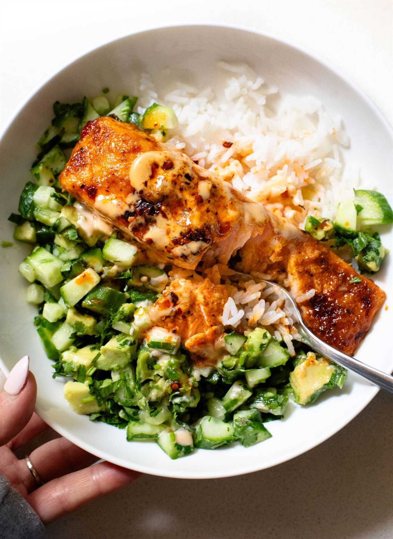 Bang bang salmon in a bowl with rice.
