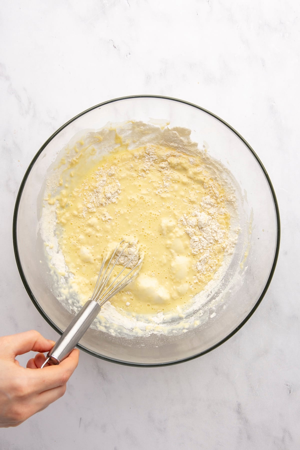 whisking flour into large bowl with milk and egg mixture