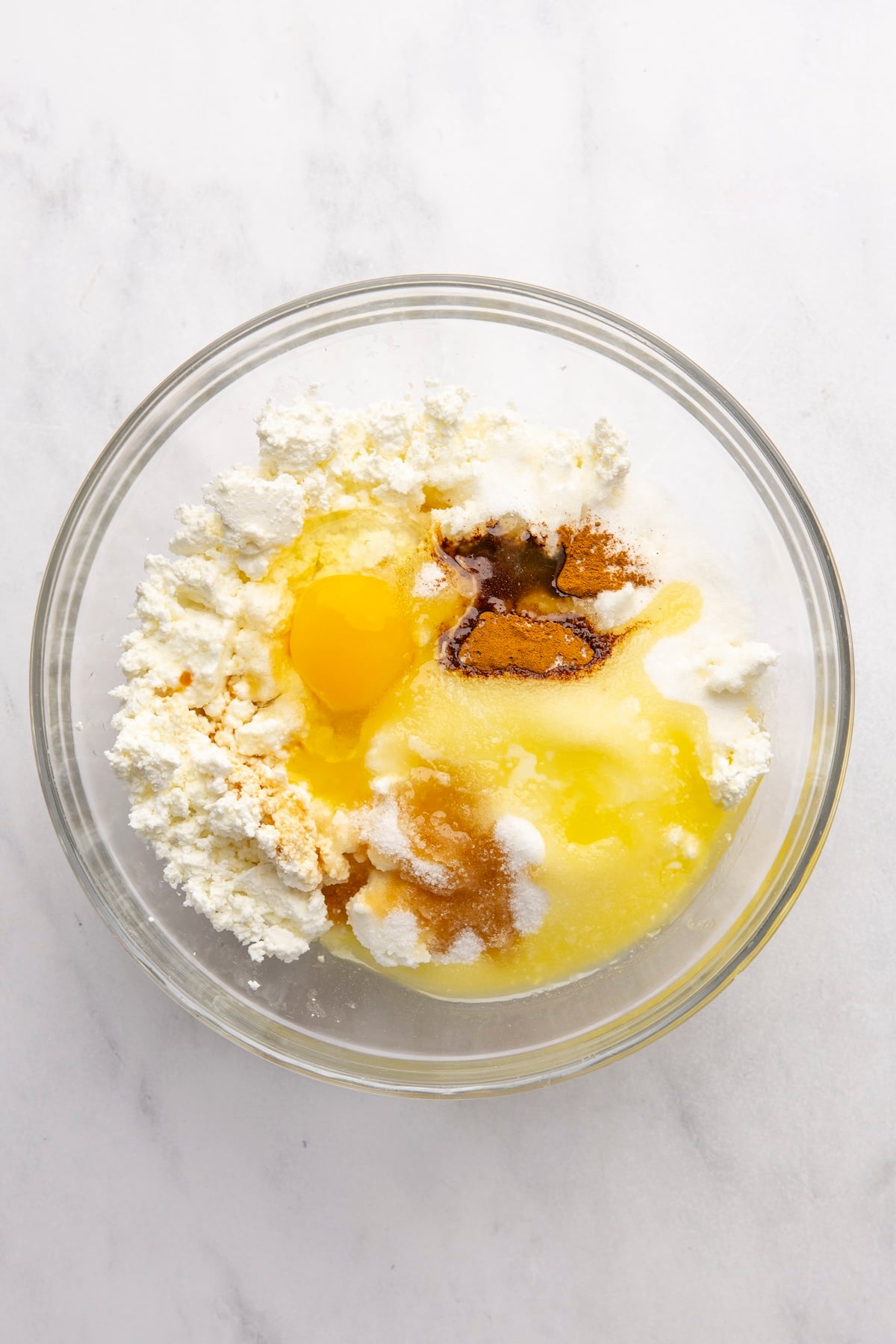 medium bowl with armer’s cheese, egg, sugar, salt, cinnamon, vanilla, and melted butter added to it