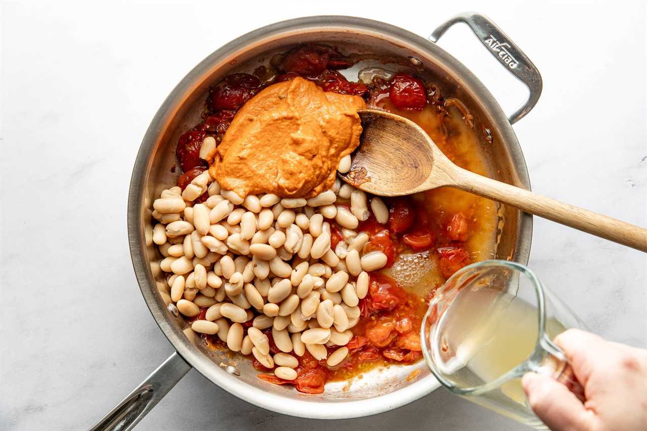 Adding beans and sauce to pan.