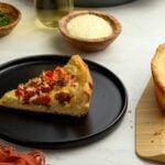 slice of deep dish pizza on black plate