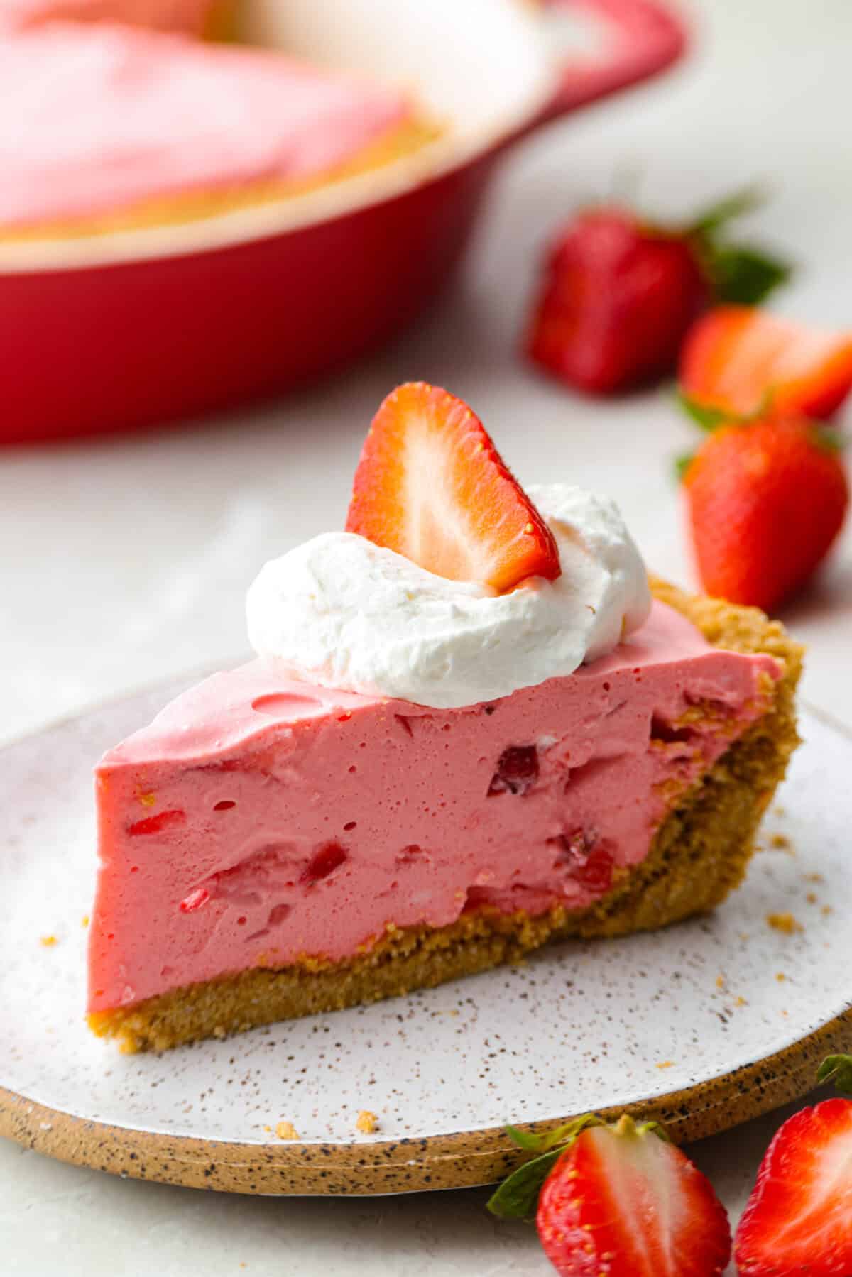 Slice of no bake strawberry cream pie on a plate.