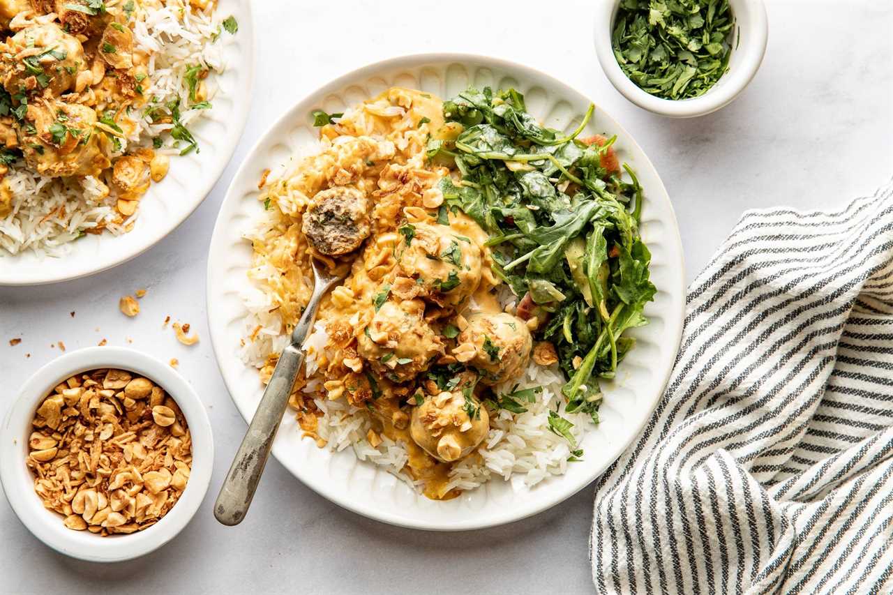 Finished meatballs on a plate with rice and greens.