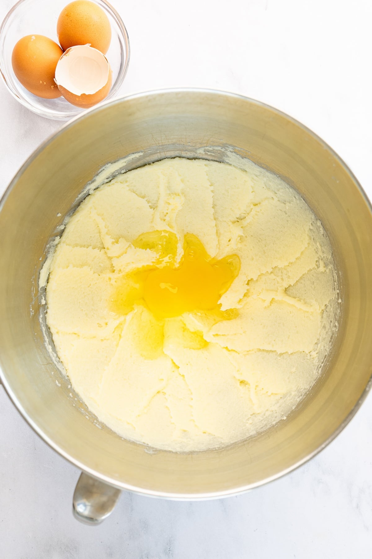 Egg added to mixing bowl with creamed butter and sugar