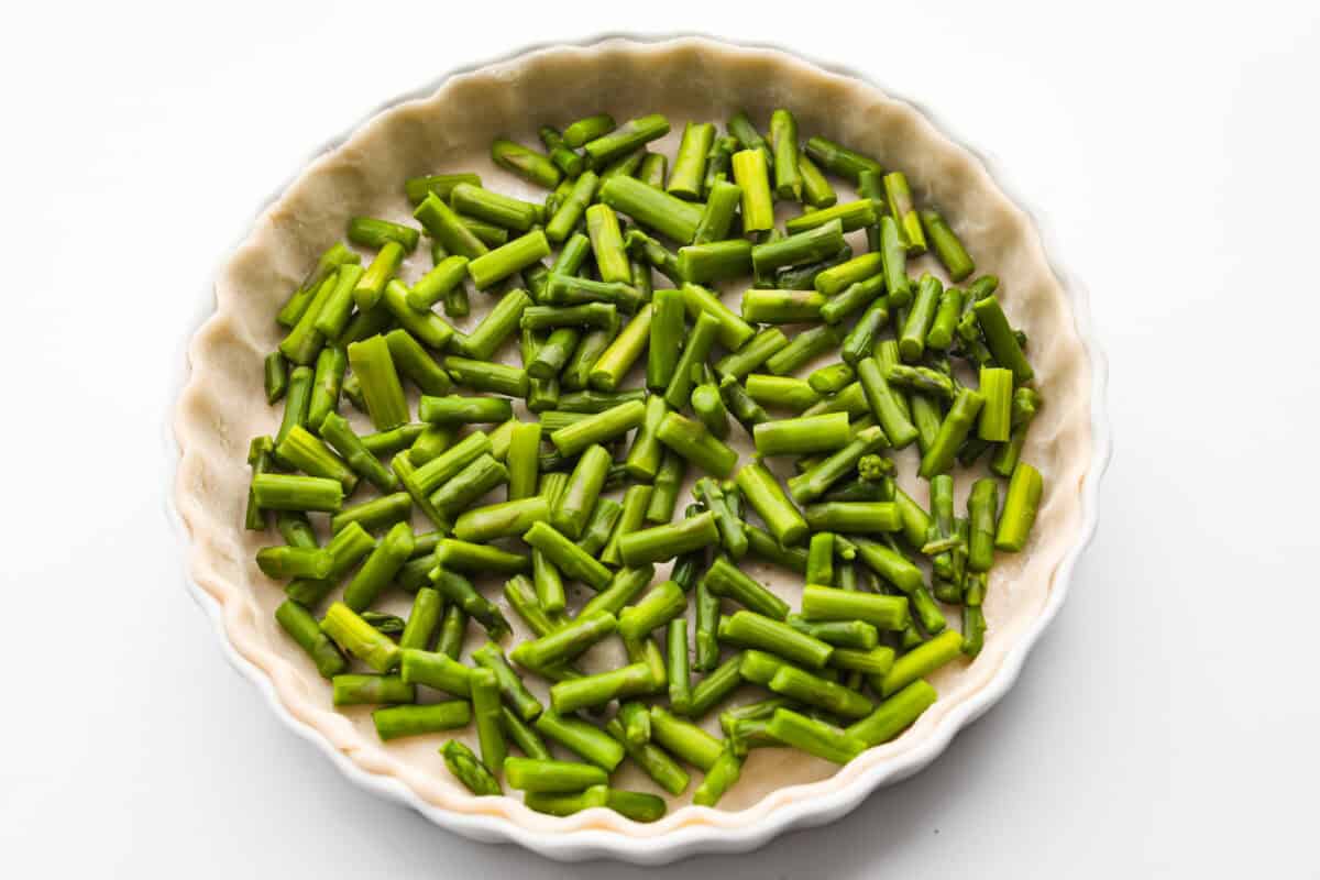 Cooked asparagus in the bottom of the pie crust. 