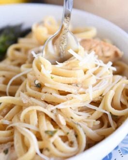 twisting pasta in white dish around fork