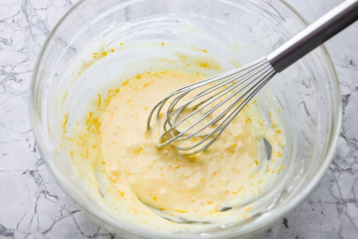 Powdered sugar, orange zest, and orange juice whisked together in a bowl. 