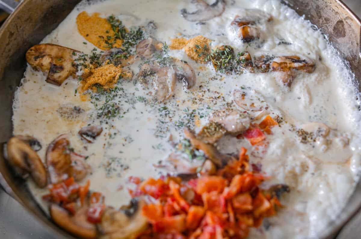 Sauce ingredients added to the skillet with the mushrooms. 