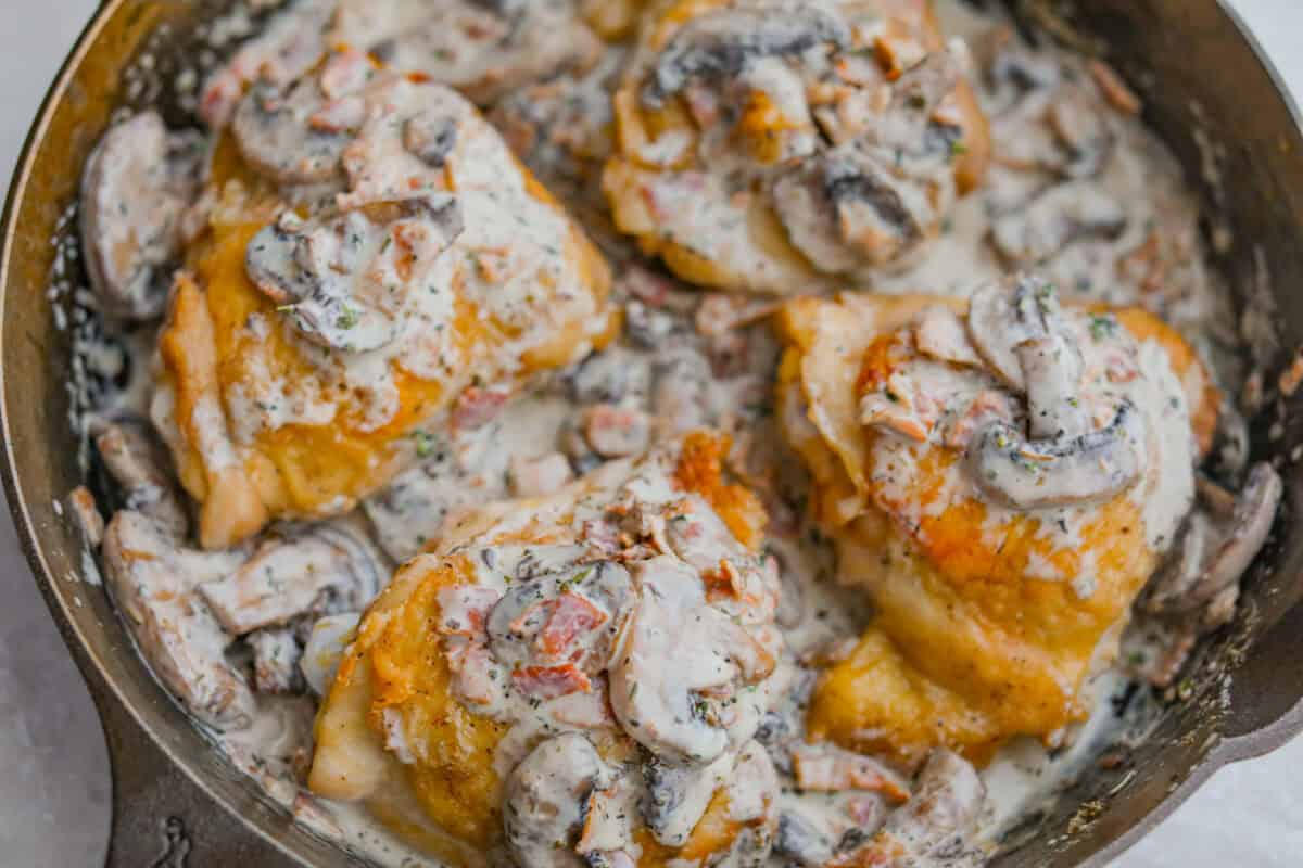 Chicken thighs added back to the skillet with the mushroom gravy sauce.