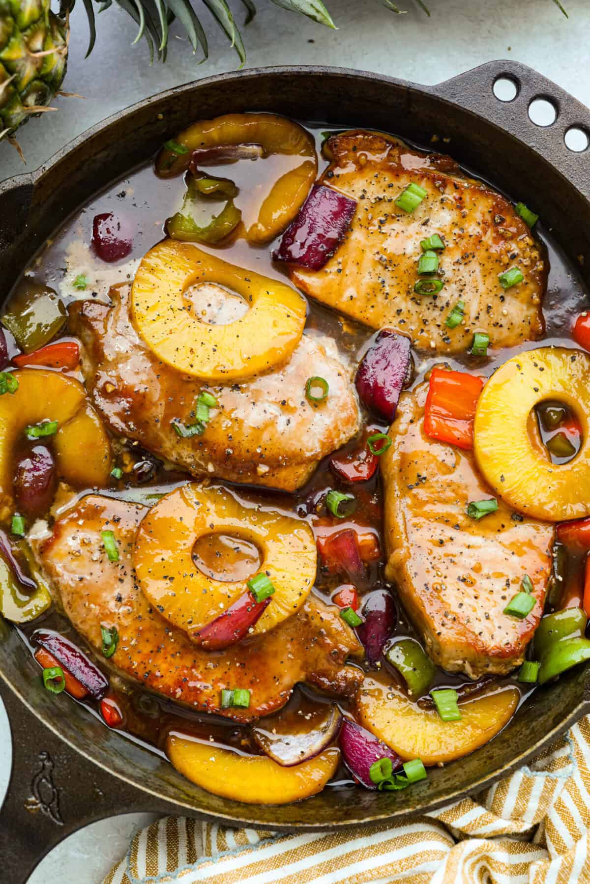 Skillet full of Hawaiian pork chops in a pineapple sauce. 