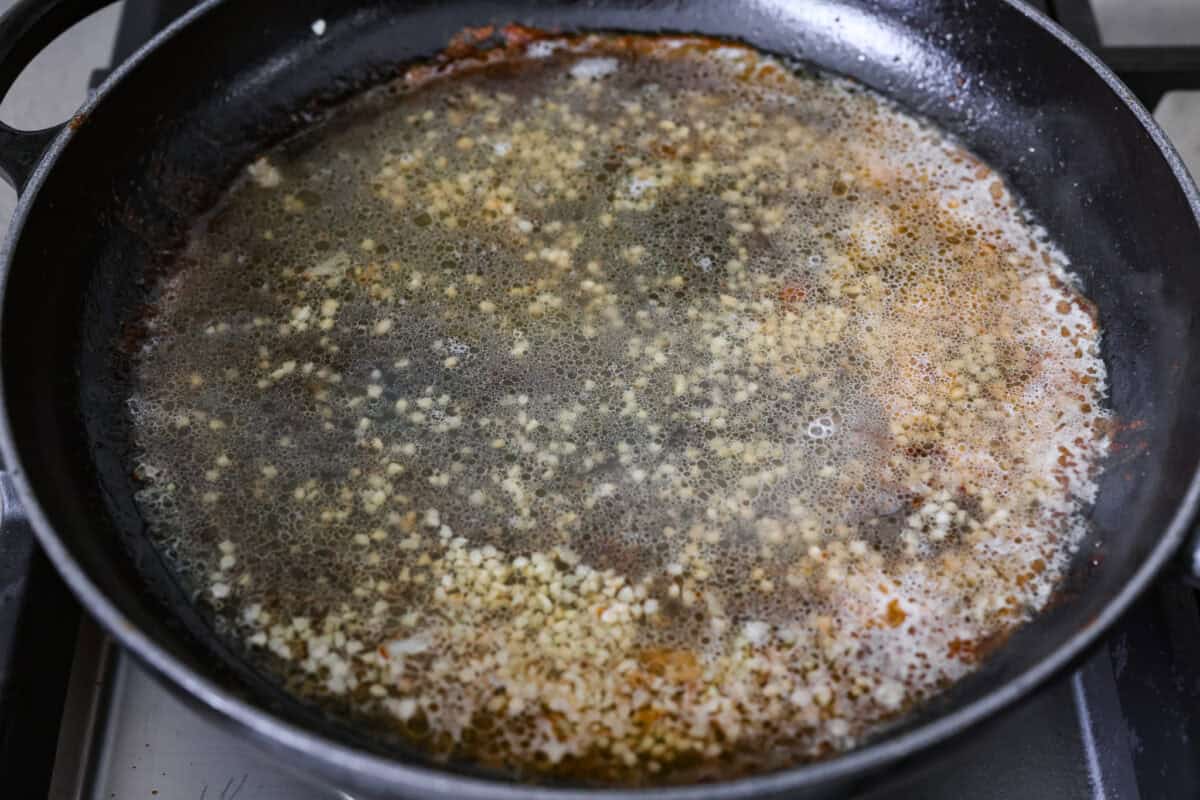 Garlic and white wine simmering in a pan. 