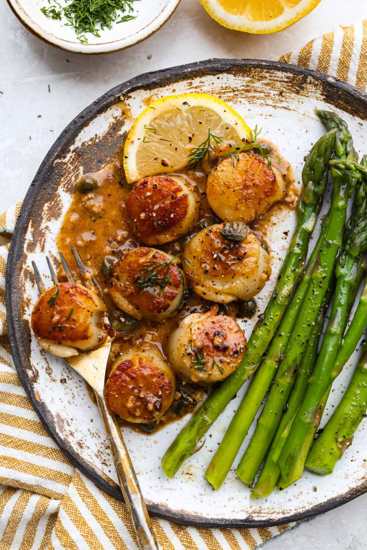 Plated pan seared scallops with asparagus.  