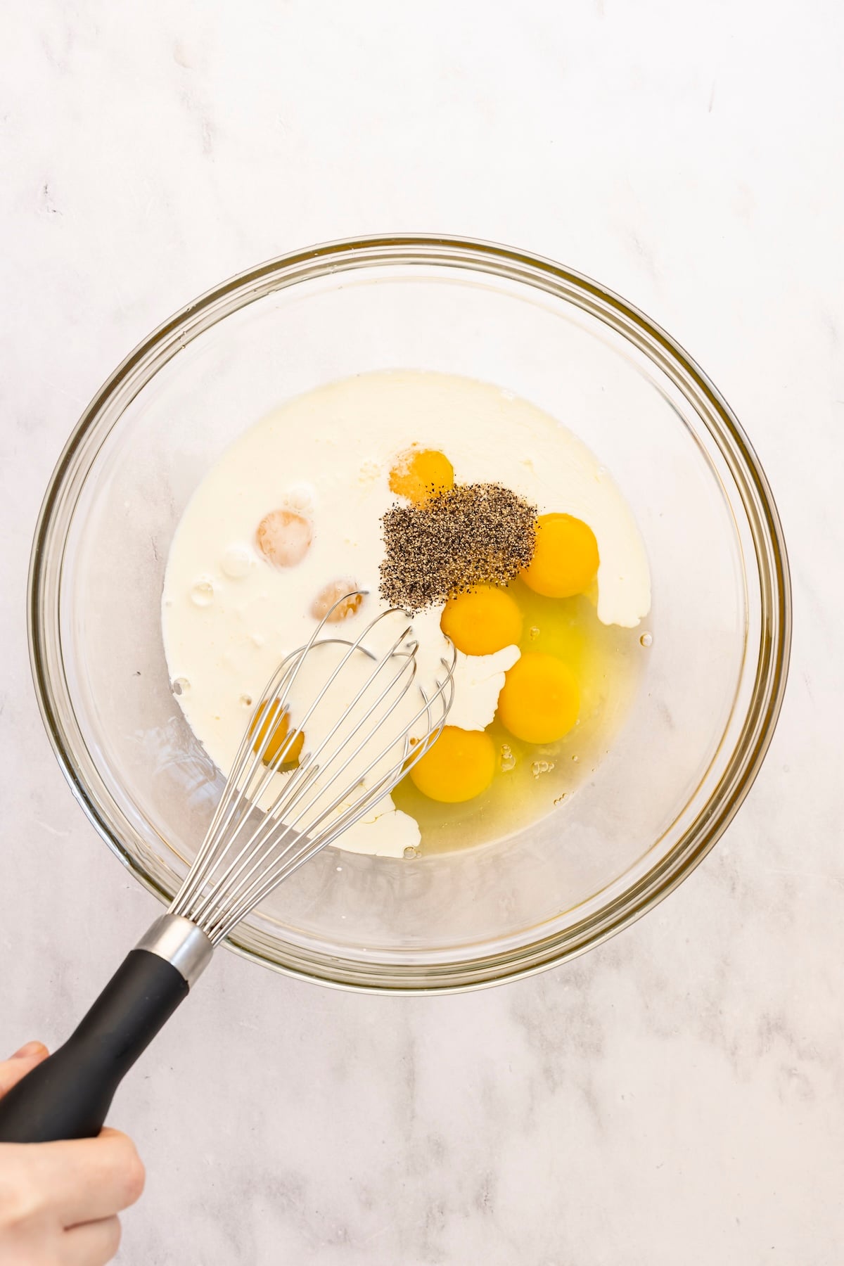 large bowl with eggs, salt, pepper, and heavy cream