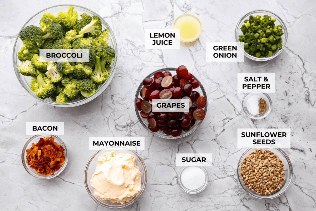 Overhead shot of labeled broccoli grape salad ingredients. 
