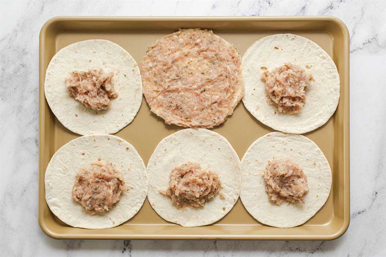 Spreading ground chicken mixture on tortillas.