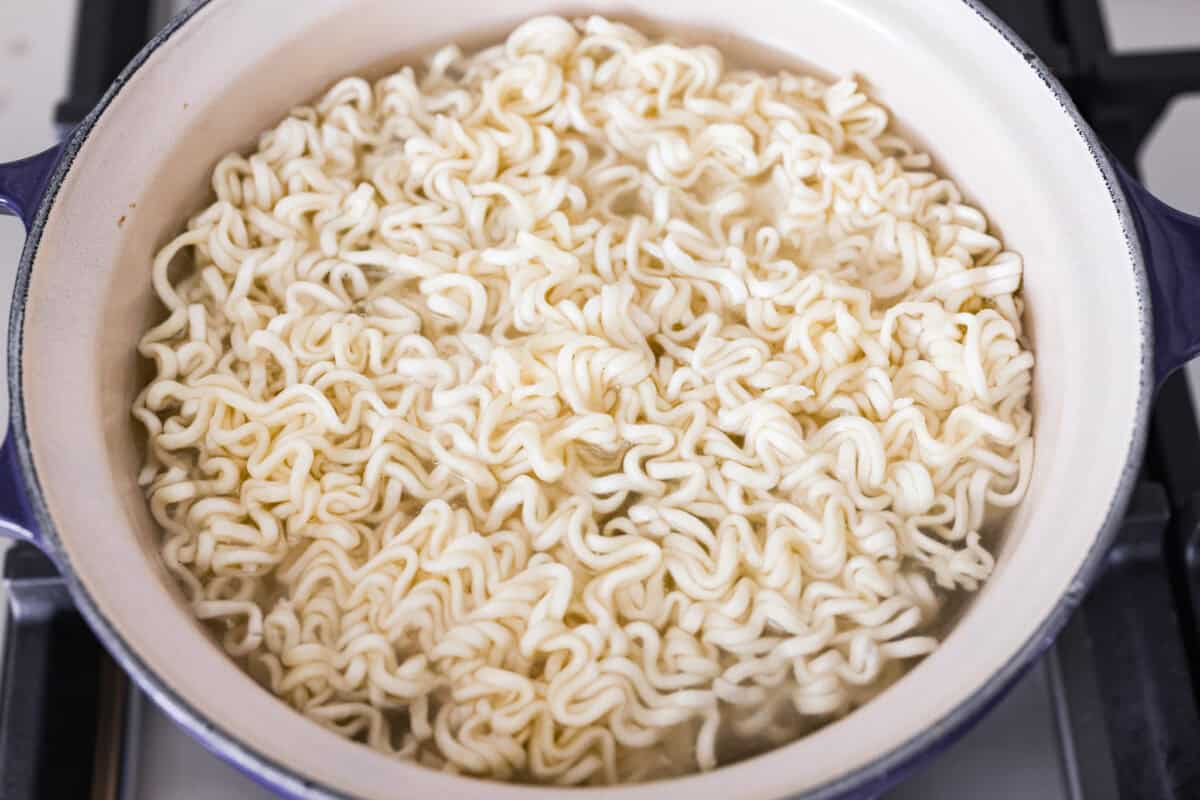 Ramen noodles cooking in a pot.