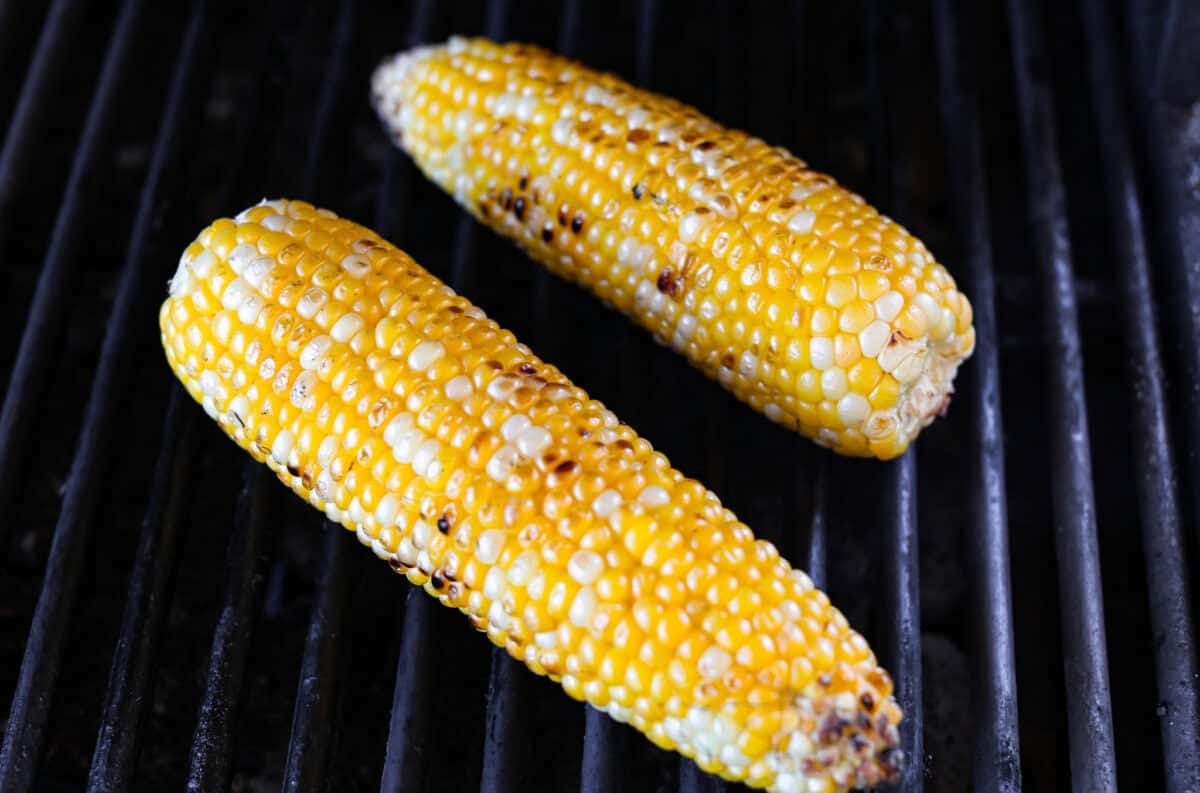 Ears of corn cooking on a grill.