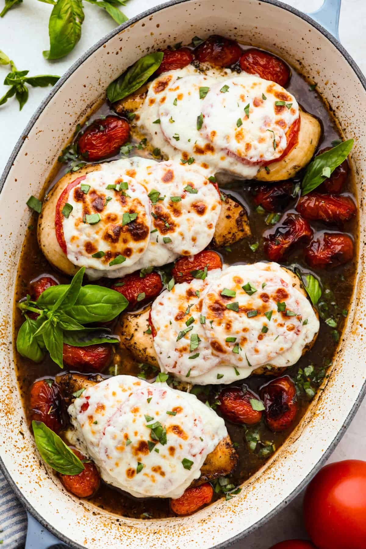 Overhead shot of a baking dish with baked caprese chicken.