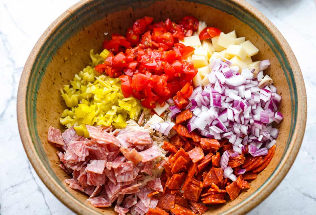 Chicken salad ingredients added to a bowl. 