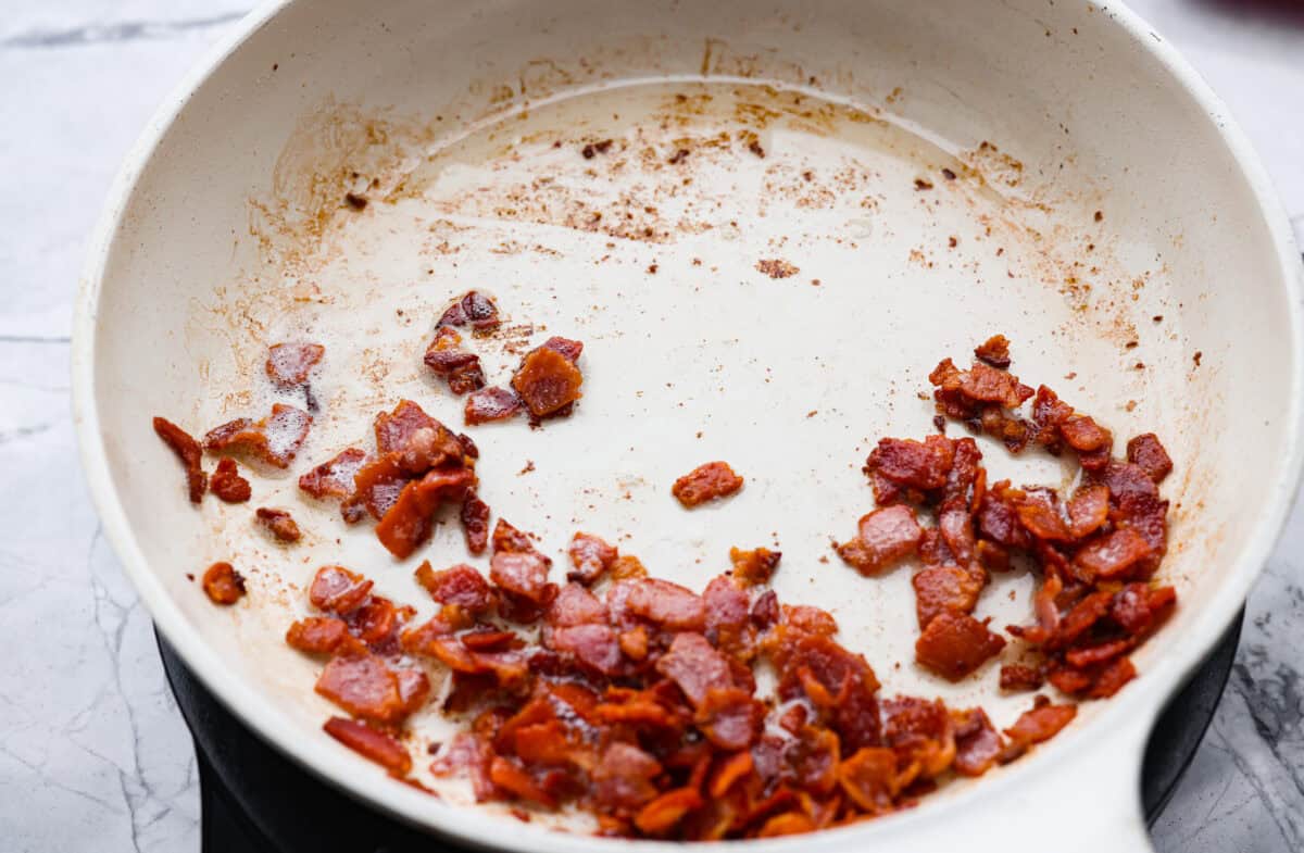 Bacon cooking in a skillet.