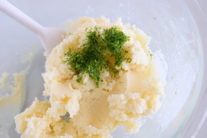 Glass bowl with creamed sugar, butter, and fresh lime zest.