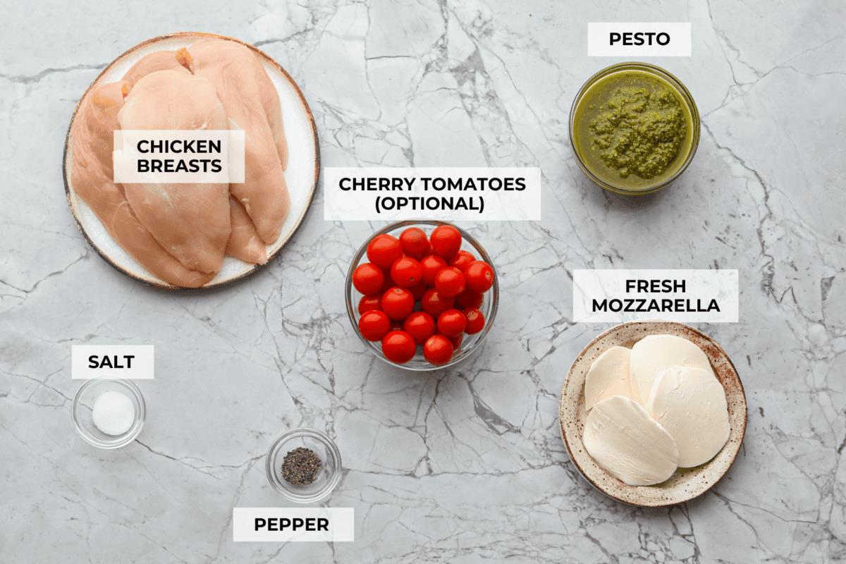 Overhead shot of labeled baked pesto chicken ingredients. 